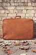 vintage suitcase on the street and bricks background