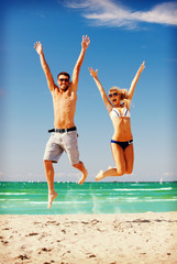 Canvas Print - happy couple jumping on the beach