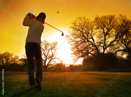 Obraz na płótnie canvas Golfista zagraj w zachodzące słońce