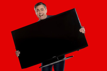 older man holding plasma screen.