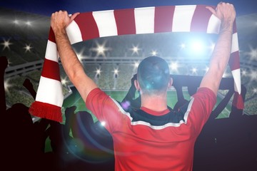 Wall Mural - Composite image of football player holding striped scarf