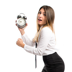 Young businesswoman holding an antique clock over white backgrou