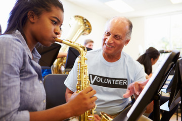 Wall Mural - girl learning to play saxophone in high school orchestra