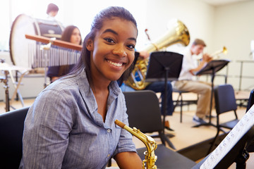 Wall Mural - female pupil playing saxophone in high school orchestra