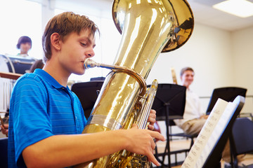 Wall Mural - Male Pupil Playing Tuba In High School Orchestra