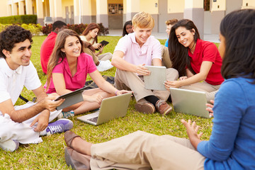 Wall Mural - high school teacher sitting outdoors with students on campus