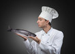 Portrait of a chef looking at the fish in his hands