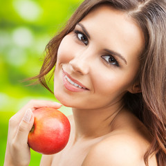 Young woman with red apple, outdoors