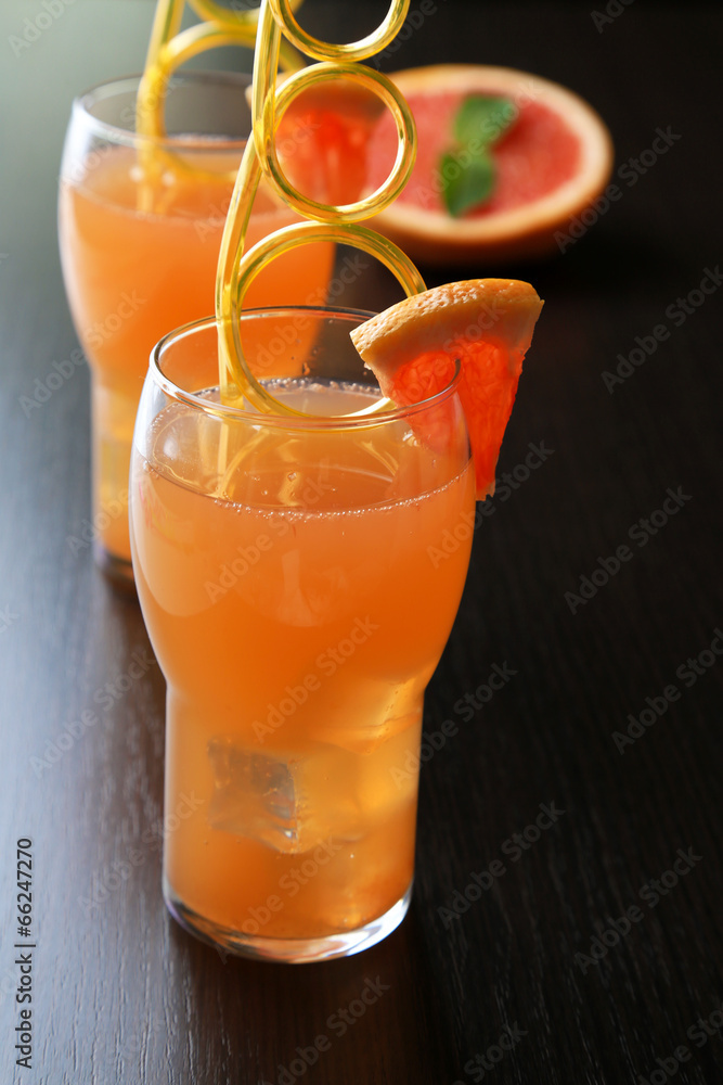Grapefruit cocktail in glasses on wooden background