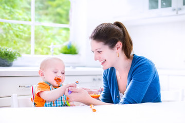 Wall Mural - Baby boy eating his first solid food