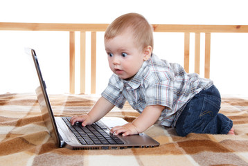 wondered baby looks at notebook screen