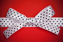 White Polka Dot Ribbon And Bow On Red Background