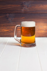 Mug of beer on wooden background