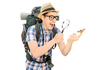 Wall Mural - Hiker looking at a butterfly through a magnifier