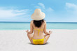 © Creativa Images - Young beautiful woman meditation on beach