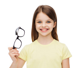 Poster - smiling cute little girl holding black eyeglasses