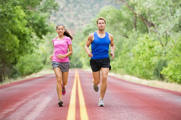 Wall Mural - Running young couple outside jogging happy smiling