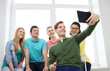 © Syda Productions - smiling students making picture with tablet pc