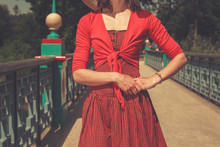 Woman Wearing A Red Dress On Bridge In A Park