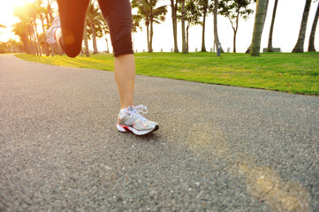 Poster - woman runner athlete legs running at tropical park