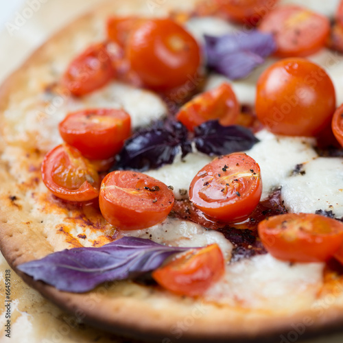 Board z aluminiowym obramowaniem Zbliżenie pizzy z czerwonymi pomidorami cherry, mozzarellą i bazylią