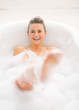 © Alliance - Happy young woman playing with foam in bathtub
