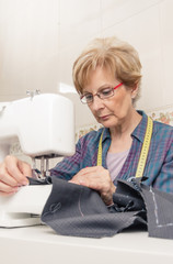 Wall Mural - Senion seamstress woman working on sewing machine