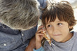© Monkey Business - Young boy listening to seashell with grandfather