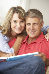 Wall Mural - Mid age couple reading book together