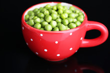 Fresh Green Peas In Red Cup Isolated On Black Background