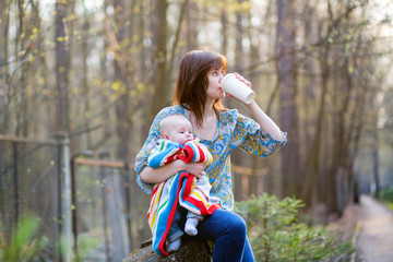 Young mother with her little baby, drinking coffee