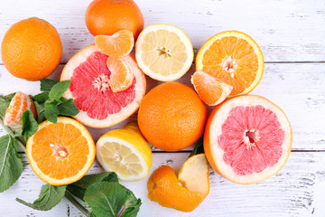 Poster - Fresh citrus fruits with green leaves on color wooden