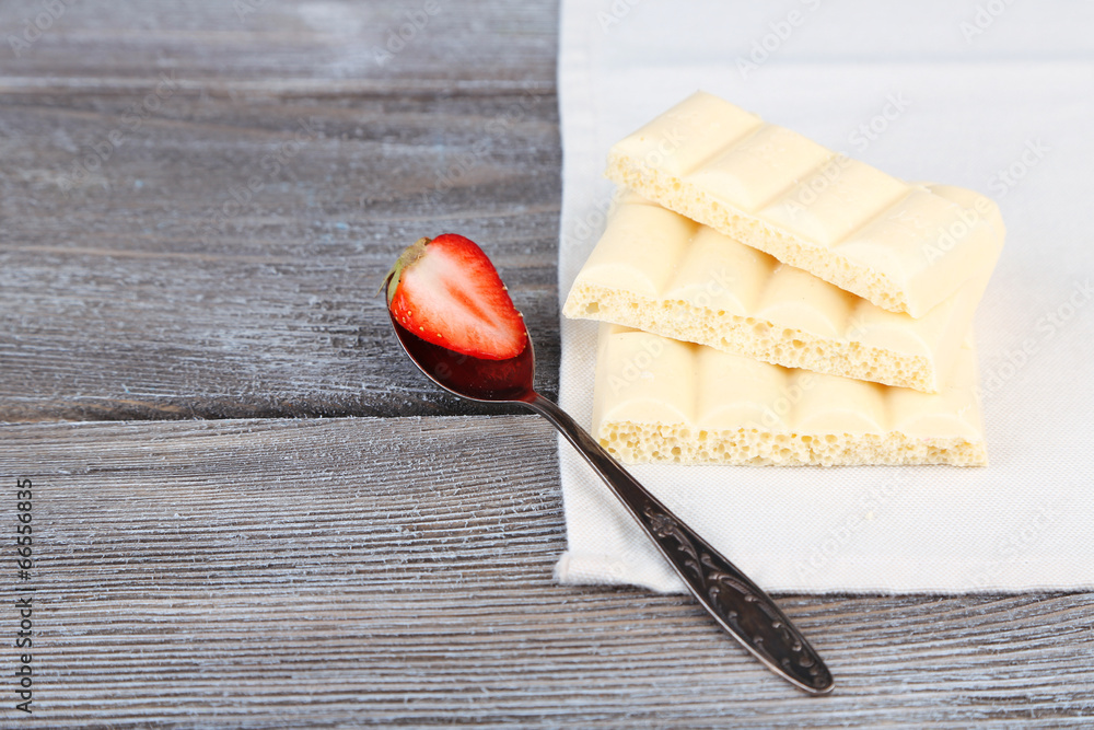 White chocolate bar on napkin on color wooden background