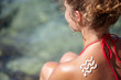 © ZoomTeam - girl back with sunburn and wave of sun lotion