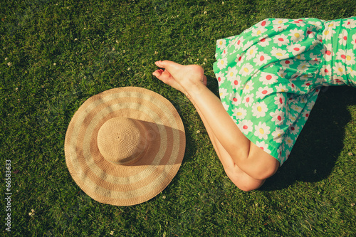 Young woman with hat sleeping in the park