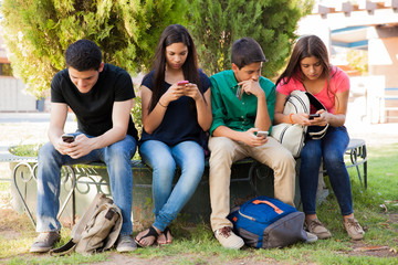 Wall Mural - Teens busy with cell phones