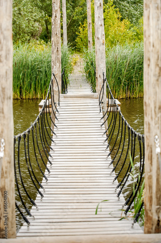 Obraz w ramie outdoor hanging bridge over the little water in the forest