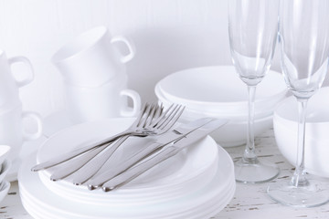 Wall Mural - Set of white dishes on table on light background