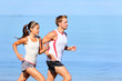 Running couple jogging on beach