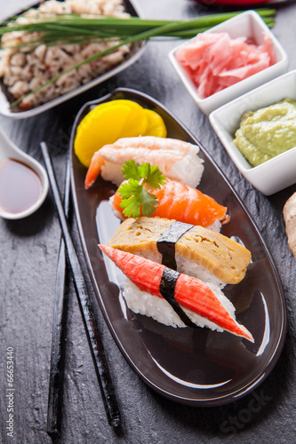 Fotoboard na płycie Pyszne kawałki sushi podawane na czarnym kamieniu