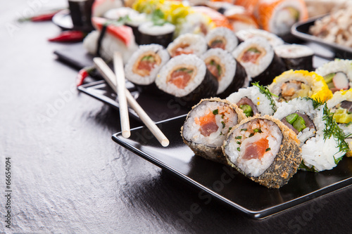 Fotoboard na płycie Pyszne kawałki sushi podawane na czarnym kamieniu