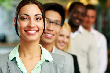 smiling businesswoman standing in front of colleagues