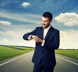 Wall Mural - man looking at his watch over road