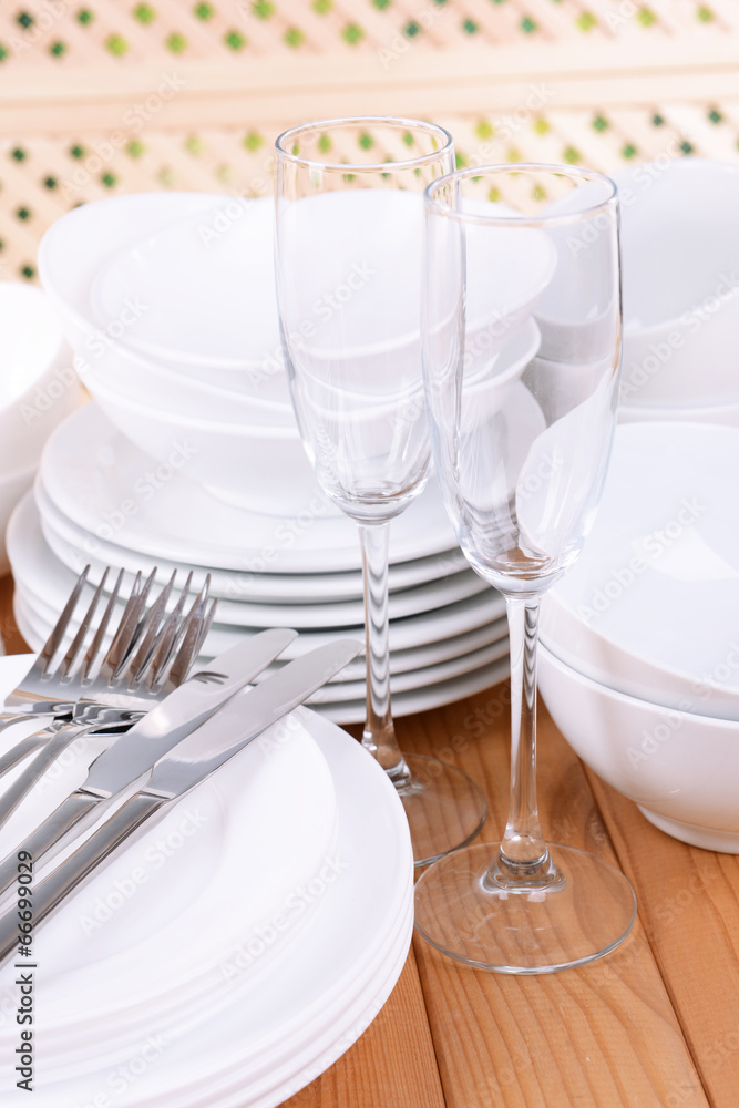 Set of white dishes on table on light background