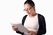 © KostaKostov - Mujer con gafas y pelo moreno leyendo documentos y estudiando propuestas de negocio en la oficina para lograr el éxito. Concepto de negocios.