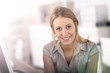 © goodluz - Portrait of beautiful office-worker sitting at desk