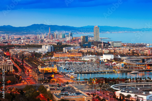 Fotoboard na płycie Port vell podczas zachodu słońca z montjuic