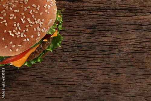 Naklejka samoprzylepna Smaczny hamburger na tle drewna. 