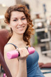 © pio3 - Young woman exercising with dumbbells in the gym.
