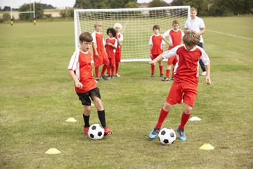 Junior football team training with coach